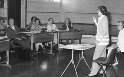 photo of Ann Hutchinson Guest teaching with participants seated at desks.